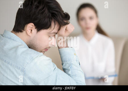 Tired young man having headache while working or visiting doctor Stock Photo