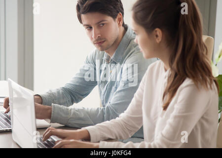 Male manager looking enviously at female rival, competition betw Stock Photo
