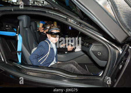 Boy tests the augmented reality in a BMW i8 using a HoloLens headset at the Intel booth at the CeBIT 2017. Stock Photo