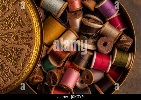 Multi colored thread in tin container Stock Photo