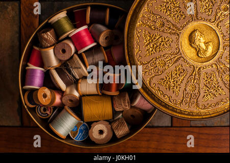 Multi colored thread in tin container Stock Photo