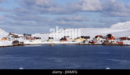 A cluster of  brightly painted houses and boat houses on a bay in the Trangsundet narrows near Havøysund.  Havøysund,  Måsøy, Finnmark,  Norway. Stock Photo