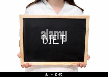 Female nurse holding a slate board with the text Diet written with chalk, isolated on white background. Stock Photo