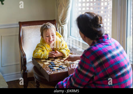 2 years-old boy playing with checkers Stock Photo