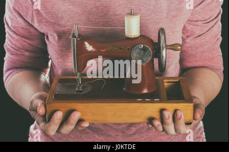 Vintage small sewing machine in woman hand Stock Photo