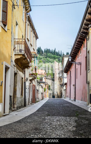 Ancient Stones Street in the Italian Walled City of Soave with Tower. The old town is surrounded by medieval crenellated walls and is near Verona. Stock Photo