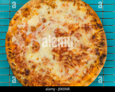 Cheese and Tomato Margherita Pizza Against a Blue Background Stock Photo