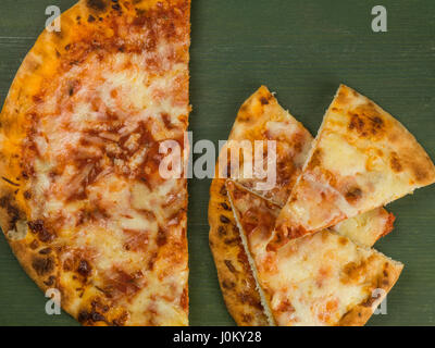 Cheese and Tomato Margherita Pizza Against a Green Background Stock Photo