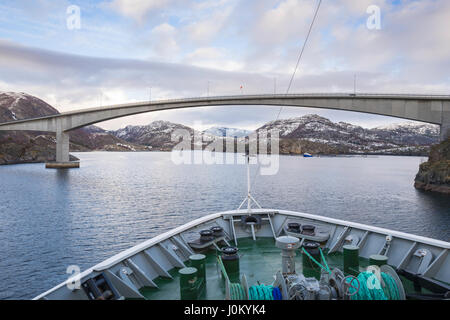 Hurtigruten ship, MS  Richard With, makes its way through the narrow strait of Stokksund, Norway, under the highway 723 bridge at Stokknes. Stock Photo