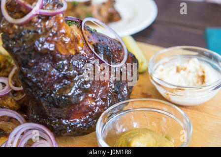 roasted pork knuckle with salad. Grilled pork meat on wooden table. Stock Photo