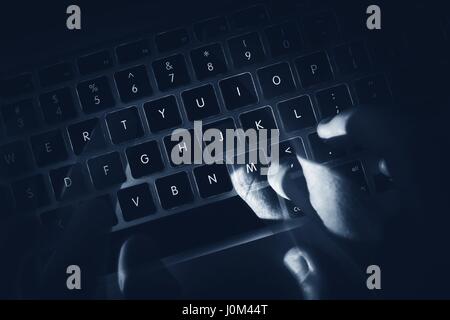 Hacker Hands in Motion on the Laptop Keyboard. Dark Computer and Network Safety Concept Photo. Stock Photo