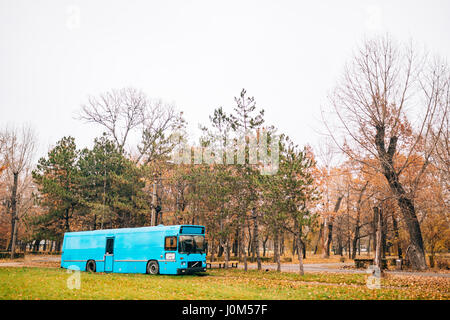 Blue bus in the park in autumn. Bus-library. Stock Photo