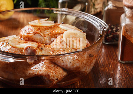 Raw chicken legs marinated in a casserole Stock Photo