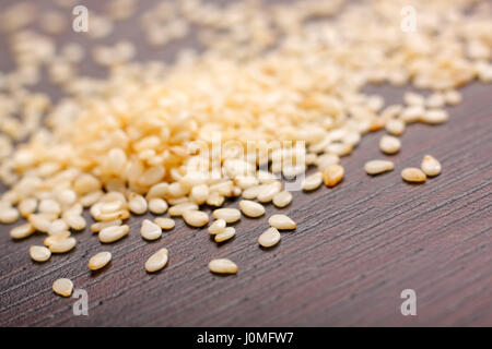 Sesame seeds (Sesamum indicum) on dark table. Close-up photo. Stock Photo