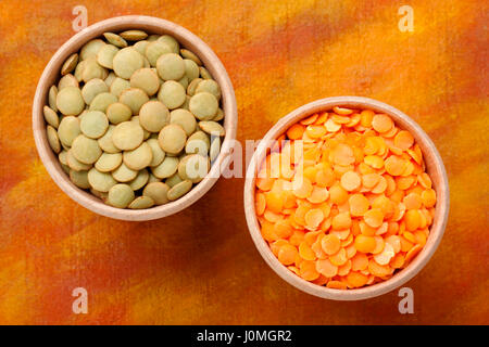 Top view of two wooden bowls with green and red lentils (Lens culinaris) Stock Photo