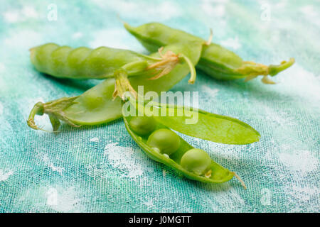 Fresh green pea pods with one pod opened. Stock Photo
