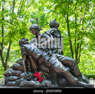 Vietnam Women's Memorial in Washington DC with roses left to honor women's service. The statue was designed by Glenna Goodacre and dedicated in 1993. Stock Photo