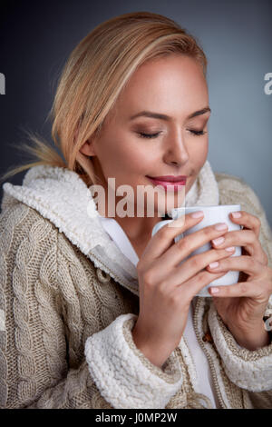 Woman in cold days warming with hot tea Stock Photo