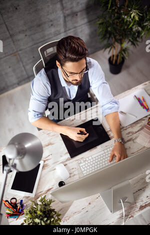 designer using graphics table to do his work at desk Stock Photo