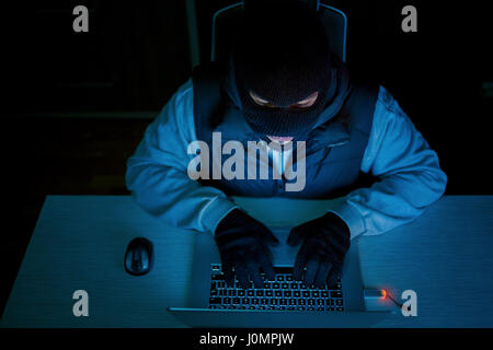 man in mask with laptop,  information security Stock Photo