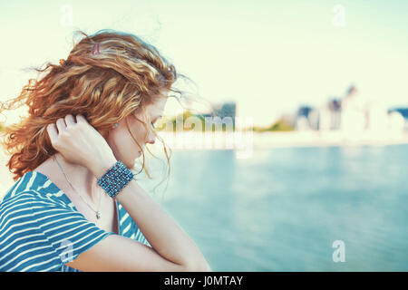 Sad redhead woman looking away over river outdoor Stock Photo