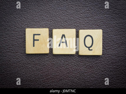 FAQ word concept wood pieces on brown leather Stock Photo