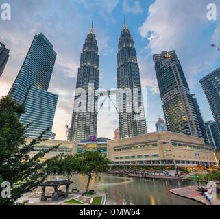 Kuala Lumpur, Malaysia - March 14, 2016: Petronas TwinTowers and Suria KLCC shopping mall at sunset, Kuala Lumpur, Malaysia on March 14, 2016. Stock Photo