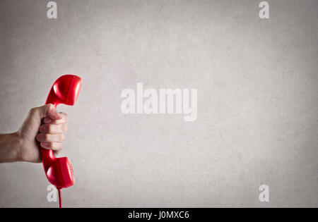 Hand holding red phone Stock Photo