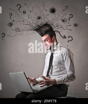 Man being mad in front of laptop Stock Photo
