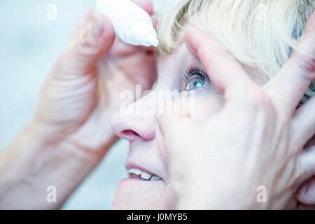 Close-up of person applying eye drops. Stock Photo