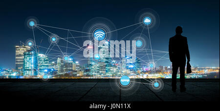 The silhouette businessman with city and wireless communication network background, abstract image visual, internet of things Stock Photo