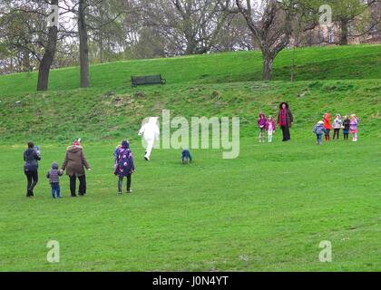 Kelvingrove Park Glasgow 14 April 2017 children playing with Easter Bunny character in wet weather Stock Photo
