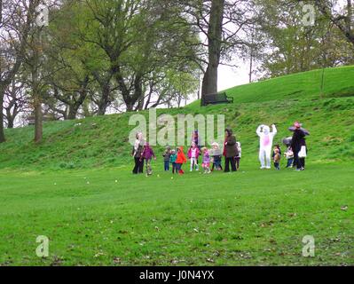 Kelvingrove Park Glasgow 14 April 2017 children playing with Easter Bunny character in wet weather Stock Photo