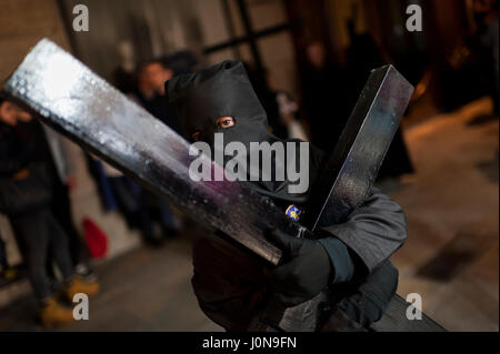 Spain, Barcelona. 14 April, 2017. A young penitent drags a cross during the Holy Week procession. Credit: Charlie Perez/Alamy Live News Stock Photo