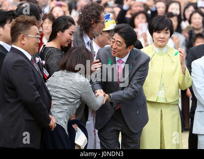 Tokyo, Japan. 15th Apr, 2017. Japanese Prime Minister Shinzo Abe (C) accompanied by his wife Akie (R) shakes hands with an invited guest during the cherry blossom viewing party at the Shinjuku Gyoen park in Tokyo on Saturday, April 15, 2017. More than ten thousands of invited guests enjoyed the annual garden party hosted by Abe. Credit: Yoshio Tsunoda/AFLO/Alamy Live News Stock Photo