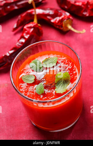 Spicy tomato soup in glass with mint leaves and ground paprika Stock Photo