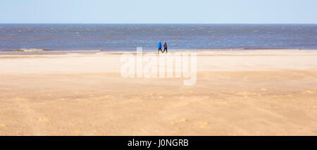 People walking along Holkham Beach, a vast sandy beach on North Norfolk coast, UK Stock Photo