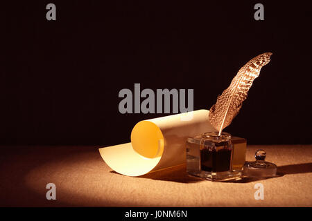 Literature Symbol. Old inkstand near scroll on canvas background Stock Photo