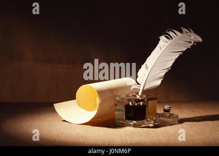 Literature Symbol. Old inkstand near scroll on canvas background Stock Photo