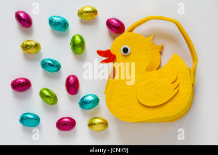 Felt chick with Easter eggs - choccy eggs solid milk chocolate eggs - isolated on white background - ready for Easter Stock Photo