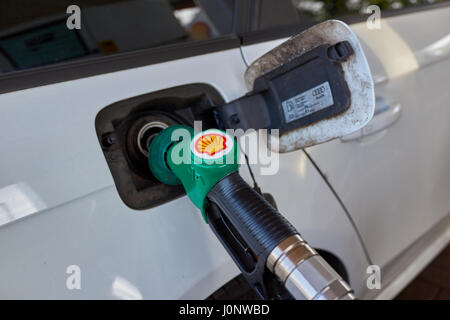 Filling up car with unleaded petrol at shell service station. Stock Photo