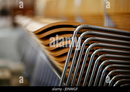 Wooden chairs with metal frame stacked neatly Stock Photo