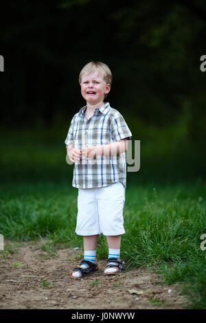 young crying boy in summer park Stock Photo