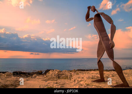 Sculpture on the beach at sunrise Stock Photo