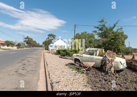 WILLOWMORE, SOUTH AFRICA - MARCH 23, 2017: A street scene in Willowmore with a sidewalk display made from an old car and wheelbarrows Stock Photo