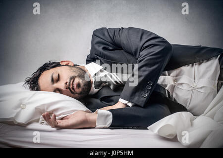 Businessman sleeping on bed Stock Photo