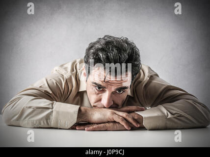 Desperate man laying on table Stock Photo