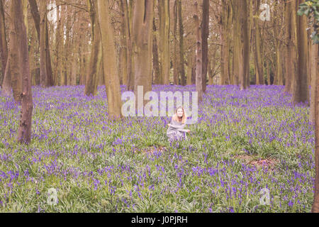 Blonde Woman in a Bluebell Wood, Wiltshire Stock Photo