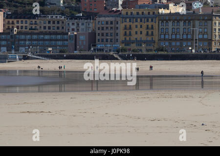 Reflection of people on the shore like a mirror in La Zurriola beach (San Sebastian, Spain) 2017. Stock Photo