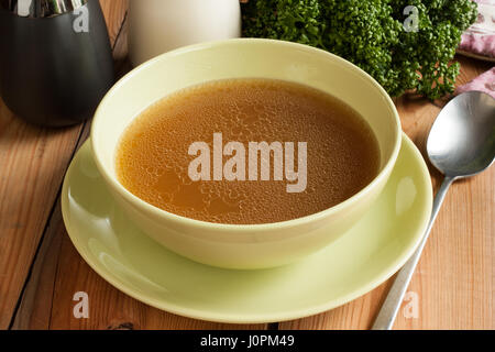 Bone broth made from beef, served in a green soup bowll Stock Photo